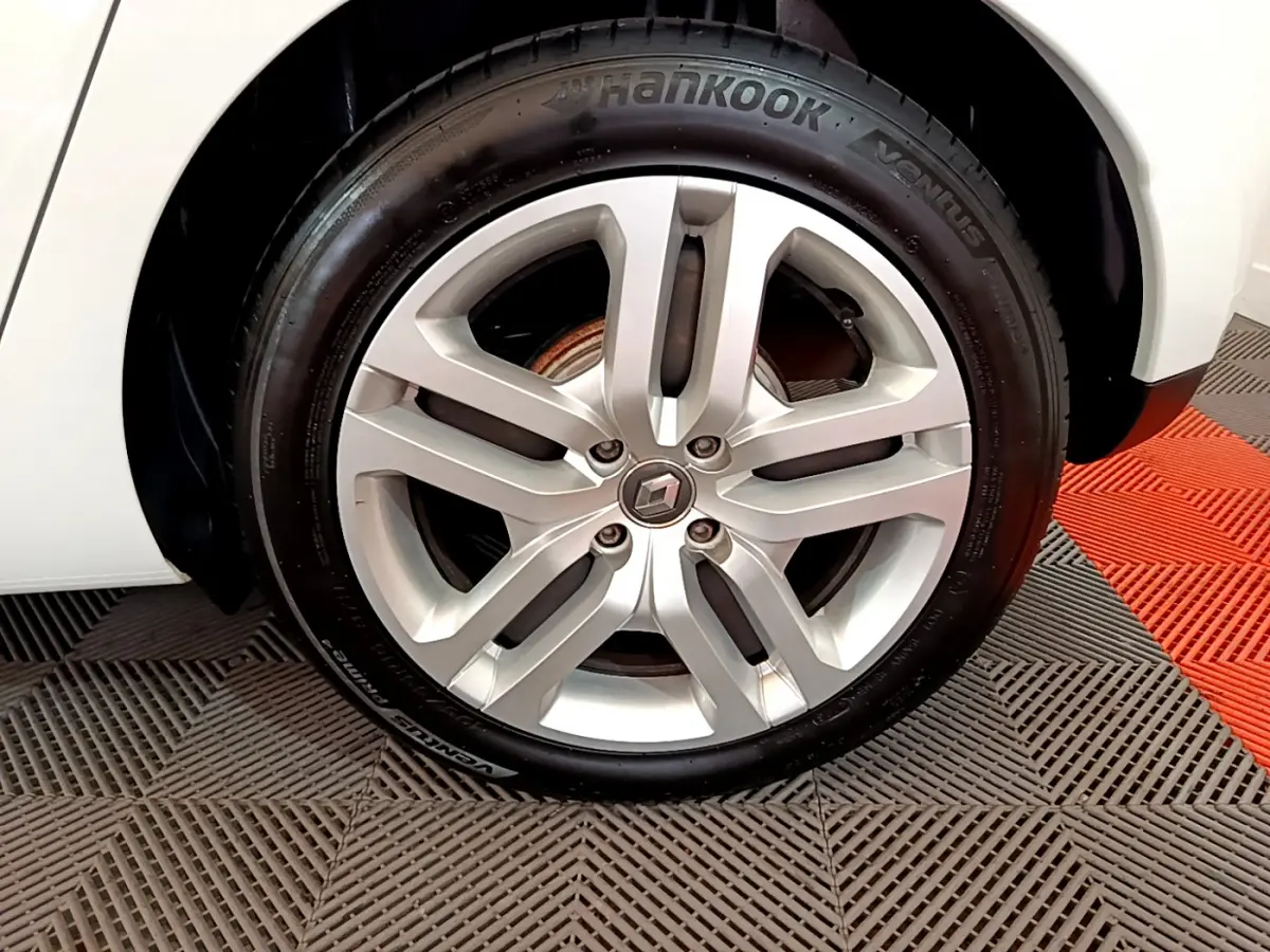 Gros plan sur la roue avant droite d'une Renault Clio Business TCe 90 blanche avec jante alliage et pneu Hankook