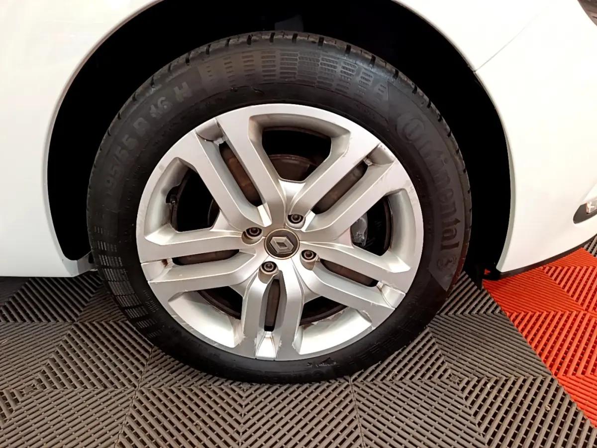 Gros plan sur la roue avant droite d'une Renault Clio Business TCe 90 blanche avec jante alliage et pneu Continental.