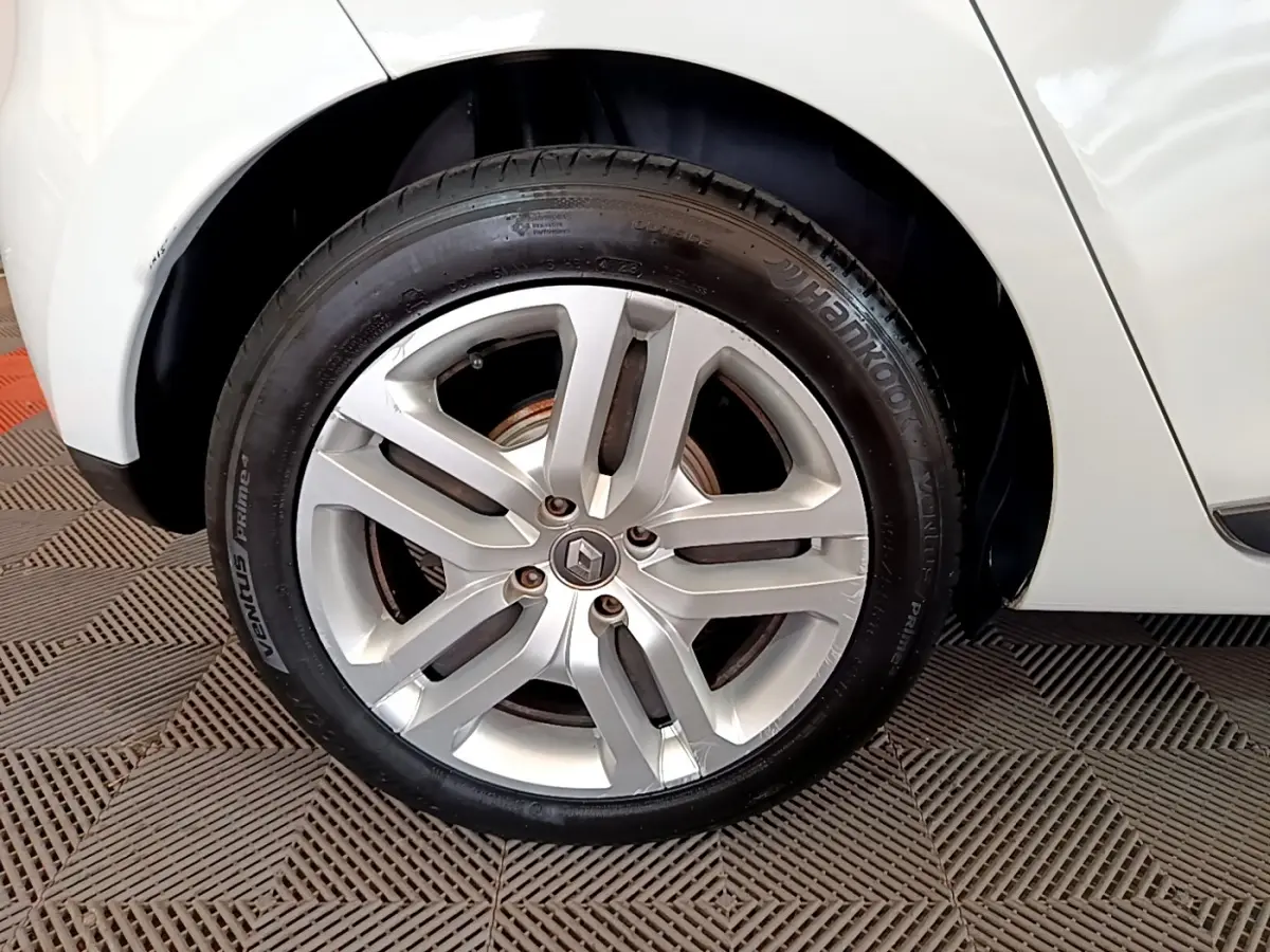 Gros plan sur la roue avant droite de la Renault Clio Business TCe 90 blanche, avec jante alliage et logo Renault visible.