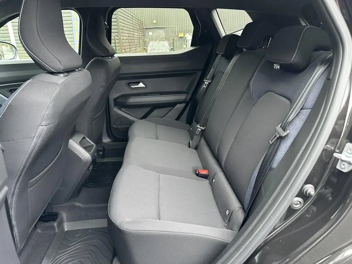 Vue côté droit de la banquette arrière noire du Dacia Duster 2025 avec ceinture et appuie-têtes intégrés.