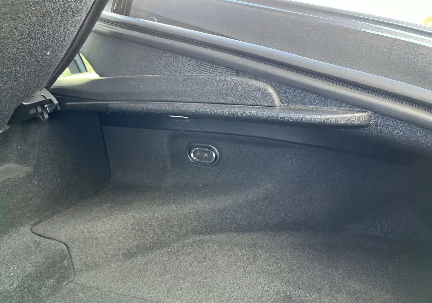 Vue intérieure du coffre arrière de la Jaguar F-TYPE II Coupé 2.0T 300 BVA8, revêtement noir et espace de rangement.