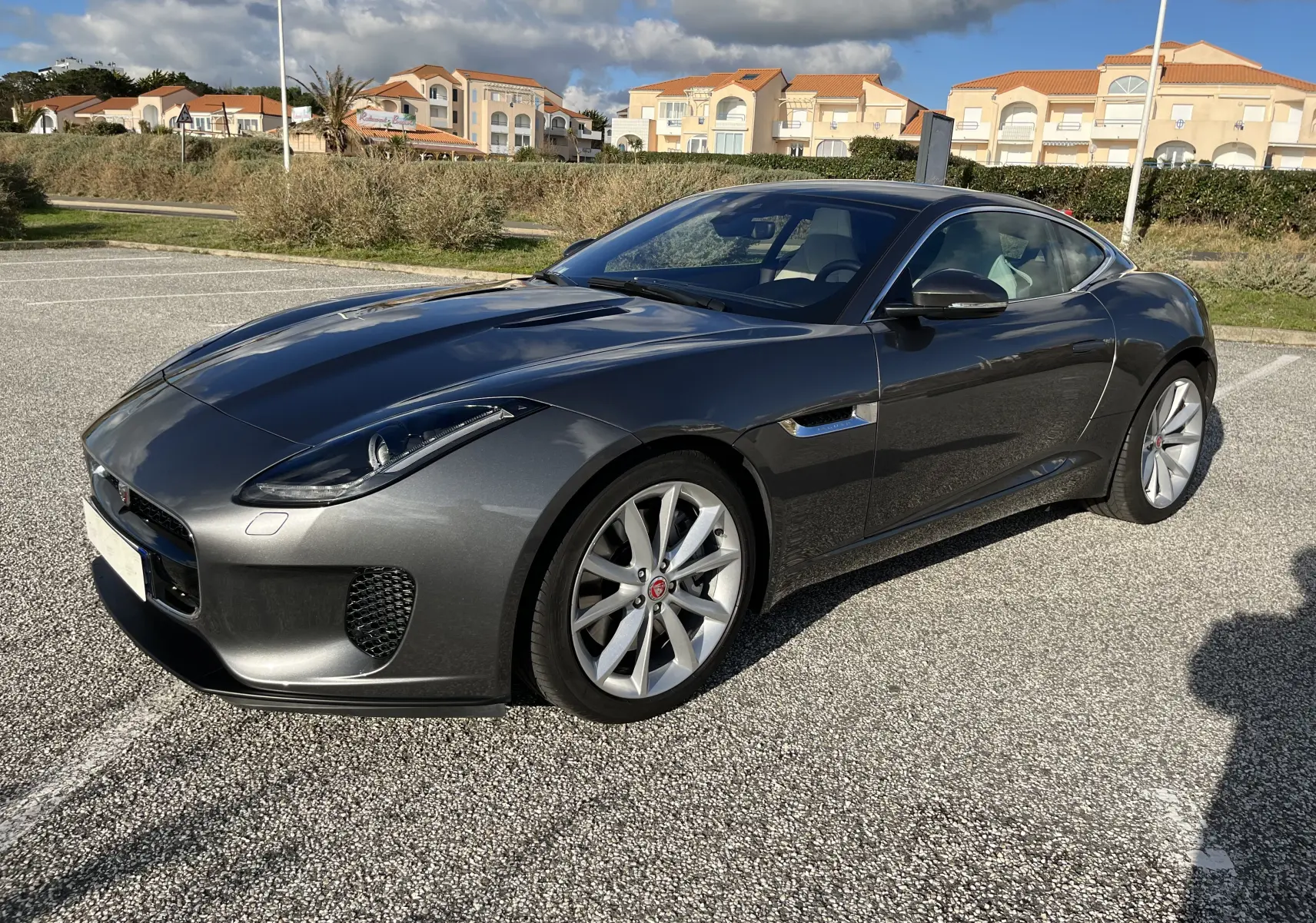 Jaguar F-TYPE II Coupé 2.0T 2018 en Corris Grey, vue 3/4 avant droit, jantes 19'' et lignes sportives marquées.