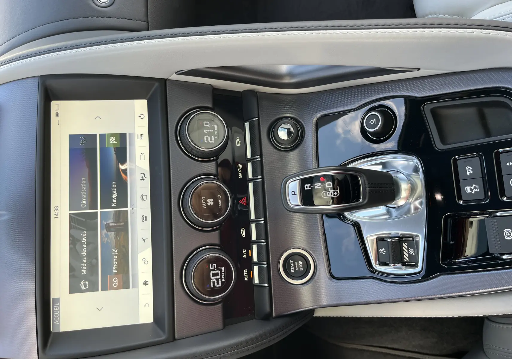 Vue rapprochée de la console centrale de la Jaguar F-TYPE 2018, avec levier de vitesse, commandes climatisation et écran tactile.