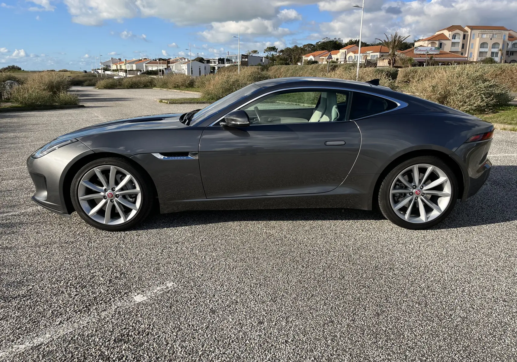 Jaguar F-TYPE II Coupé 2.0T 300 BVA8 gris Corris vue de profil côté gauche, jantes 19 pouces et lignes sportives.