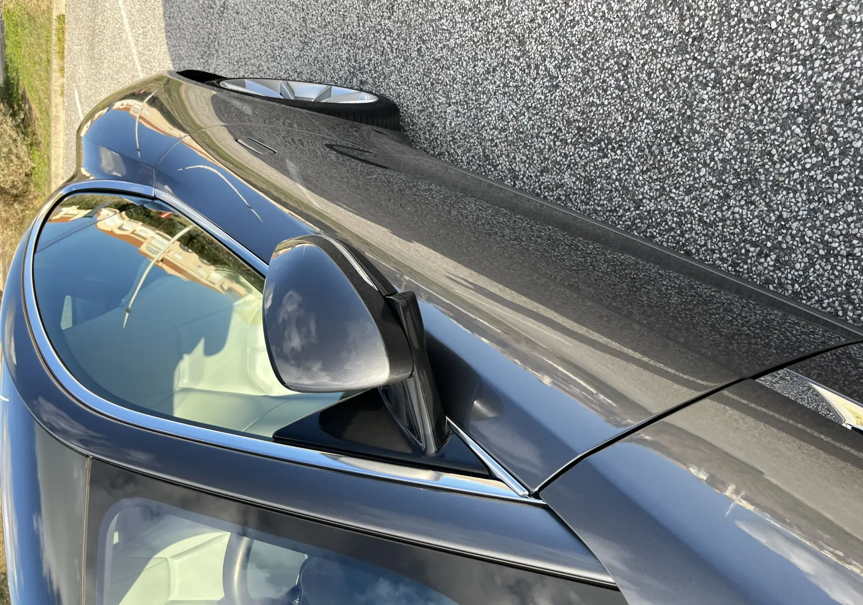 Vue en plongée du côté gauche d'une Jaguar F-TYPE II Coupé 2.0T 2018 en gris Corris avec rétroviseur et jante visibles.