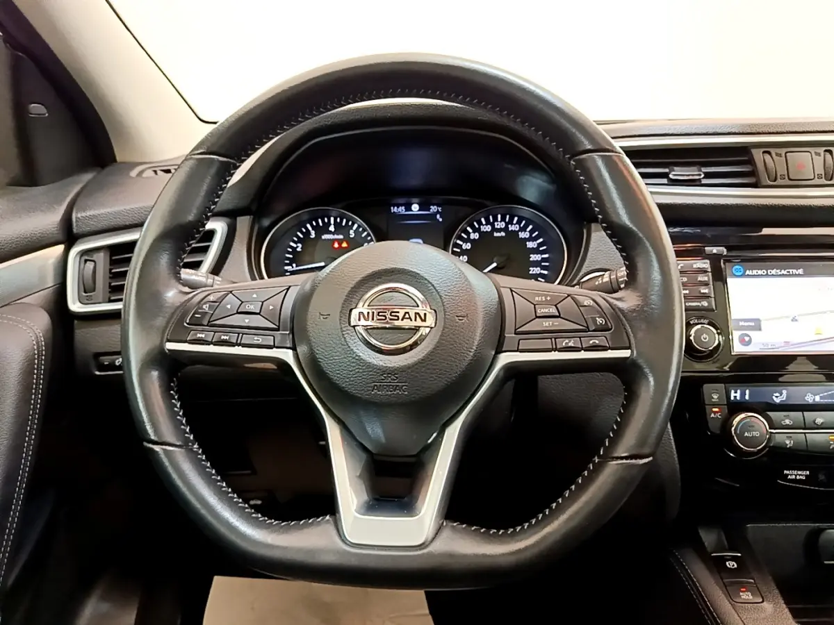 Vue intérieure centrée sur le volant cuir noir du Nissan Qashqai 1.3 DIG-T 140 Tekna avec tableau de bord et écran tactile.