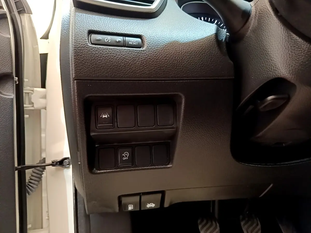 Vue rapprochée côté gauche du tableau de bord noir du Nissan Qashqai blanc avec commandes d’aide à la conduite.