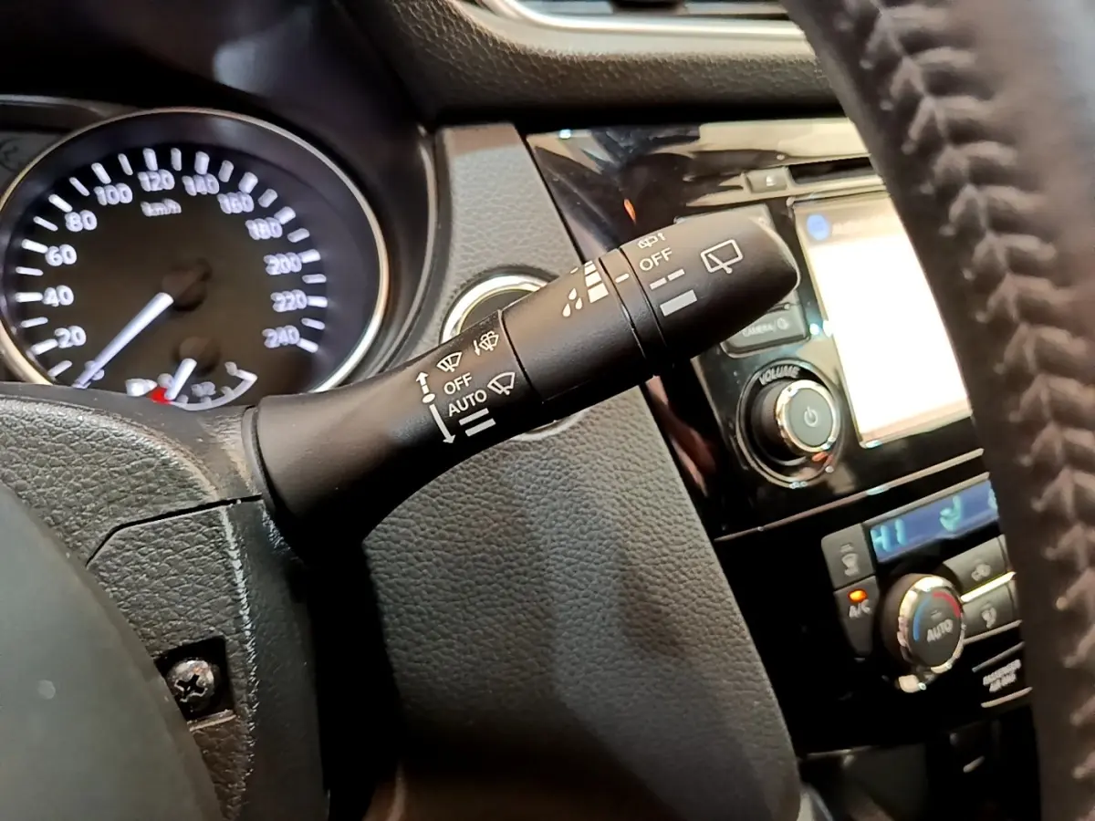 Gros plan sur la commande d'essuie-glace à gauche du volant dans l’habitacle du Nissan Qashqai blanc 2019.