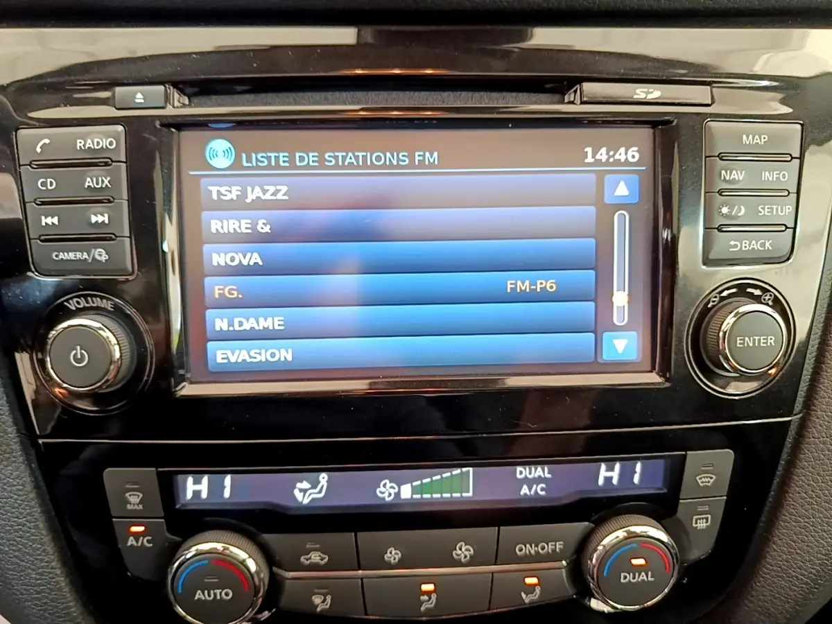 Vue rapprochée de l’écran tactile central et des commandes de climatisation du Nissan Qashqai blanc 2019.