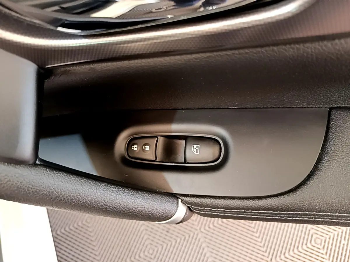 Détail des commandes de verrouillage et lève-vitres sur la porte intérieure côté conducteur du Nissan Qashqai blanc.