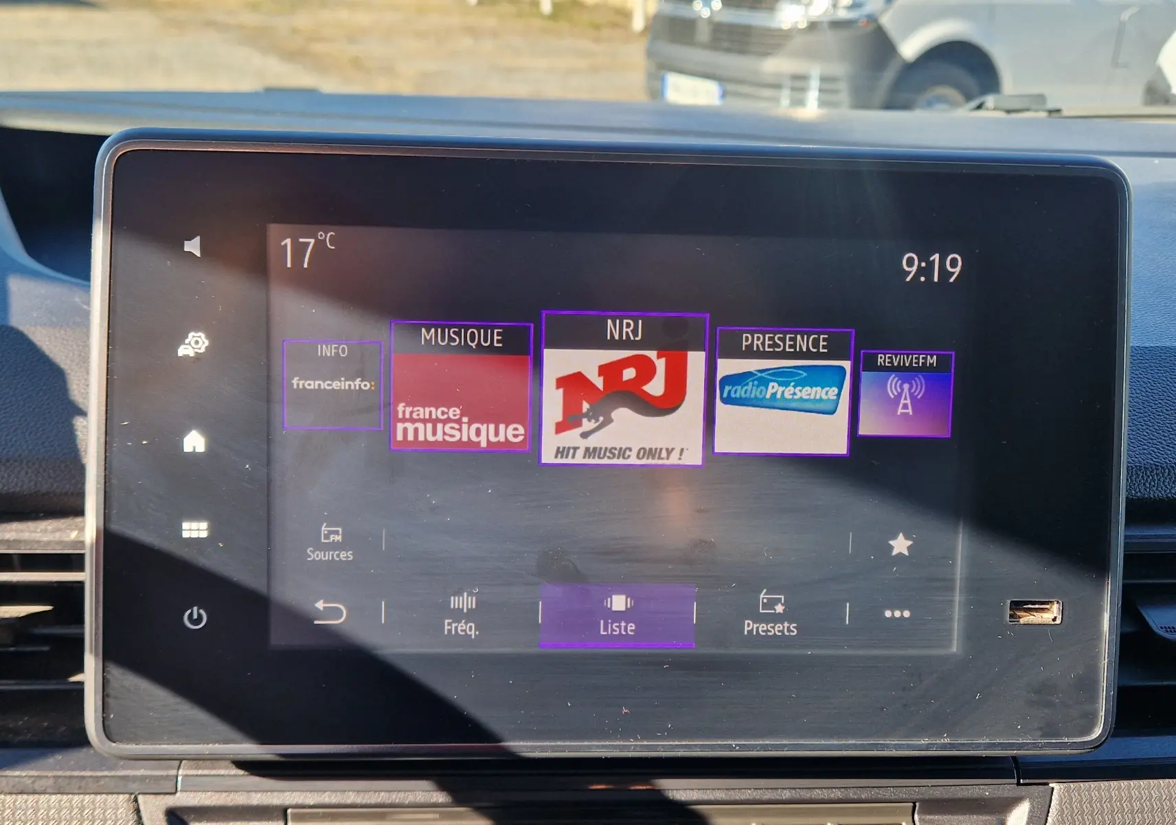 Écran tactile central du Renault Kangoo blanc 2023 affichant les stations radio avec interface moderne et commandes visibles.