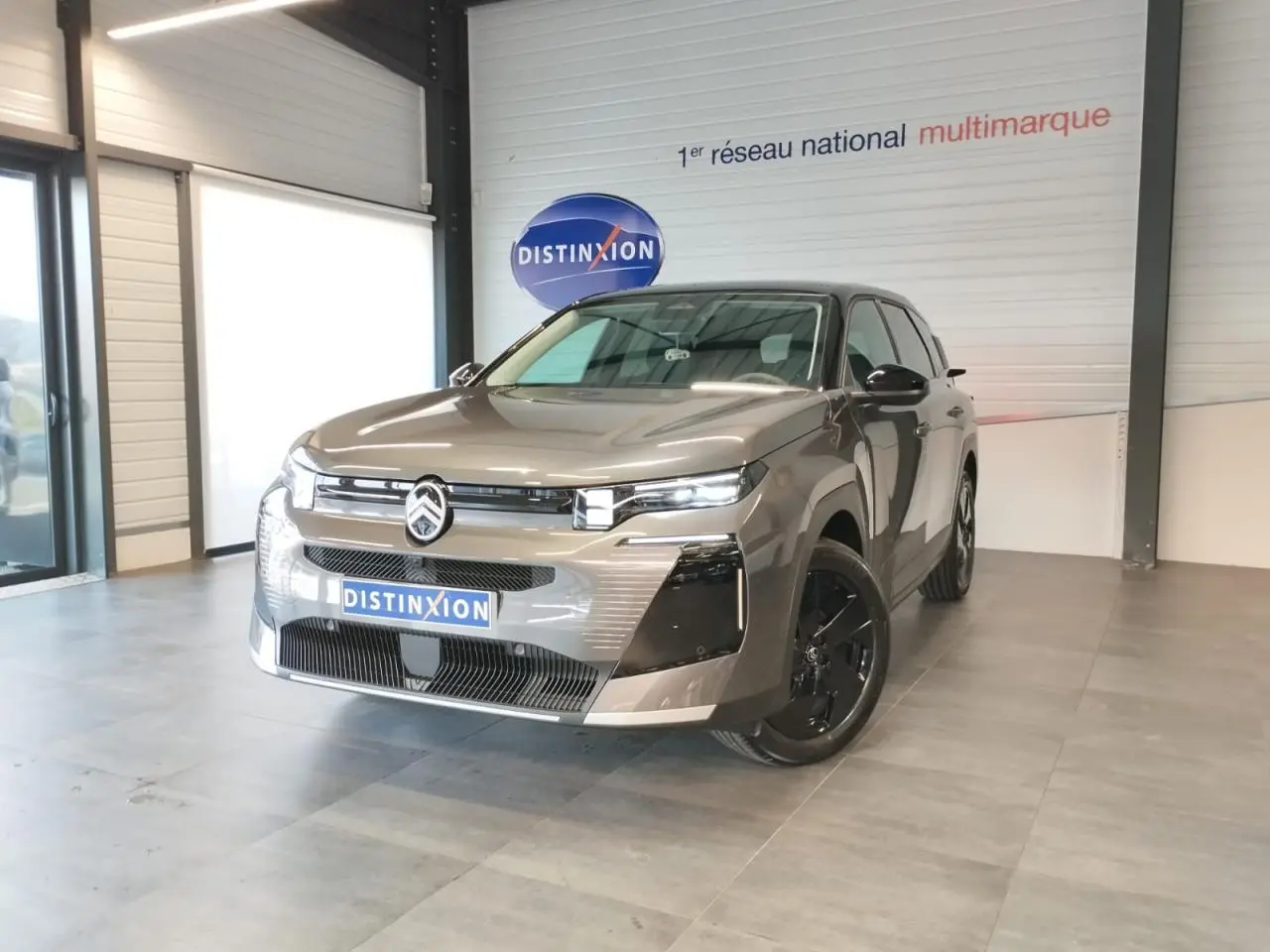 Citroën C5 Aircross gris platine vue 3/4 avant droit avec calandre noir brillant en showroom.