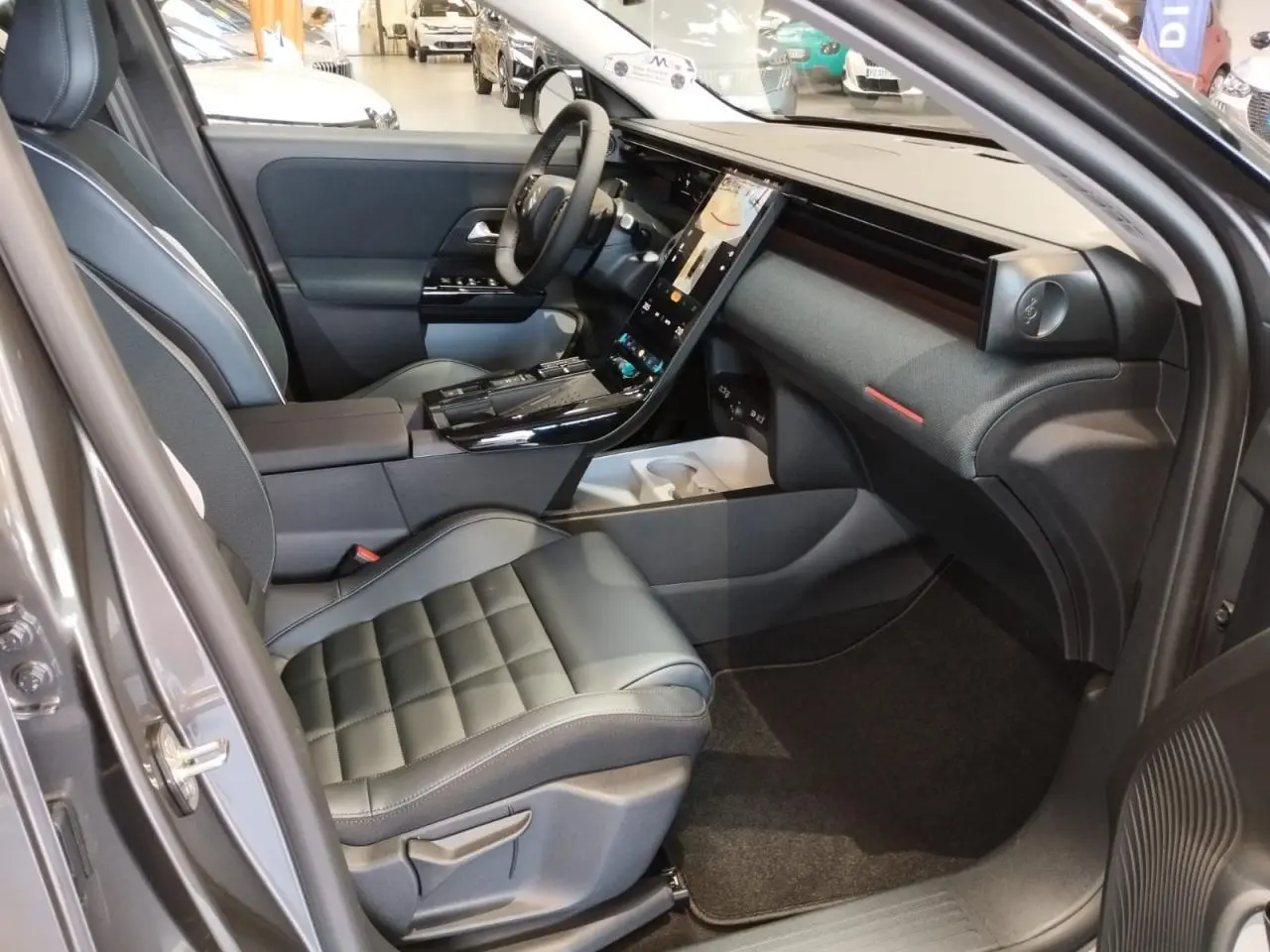 Vue intérieure côté passager avant du Citroën C5 Aircross gris platine, avec tableau de bord moderne et sièges cuir noir.