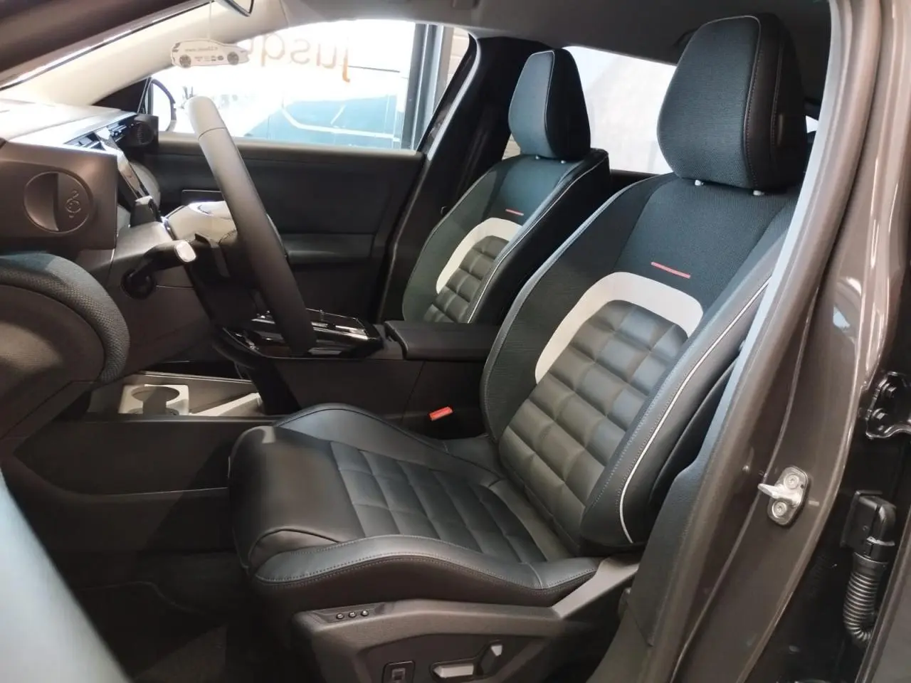Vue intérieure côté conducteur du Citroën C5 Aircross 2026, sièges avant noirs avec insert textile bleu et blanc.