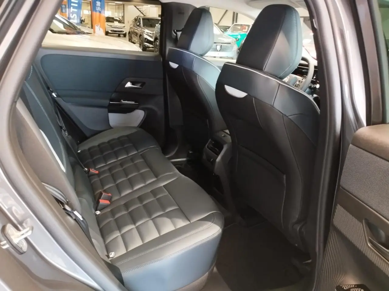 Vue intérieure arrière côté droit du Citroën C5 Aircross gris platine, montrant la banquette en cuir noir matelassé.