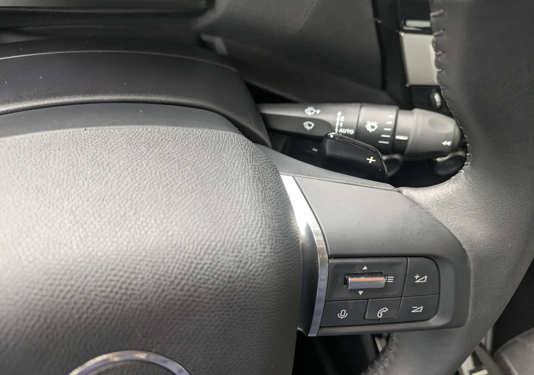 Gros plan sur le volant côté gauche de la Citroën C4 Hybrid 145 E-DCS6 Plus 2025, avec commandes intégrées.