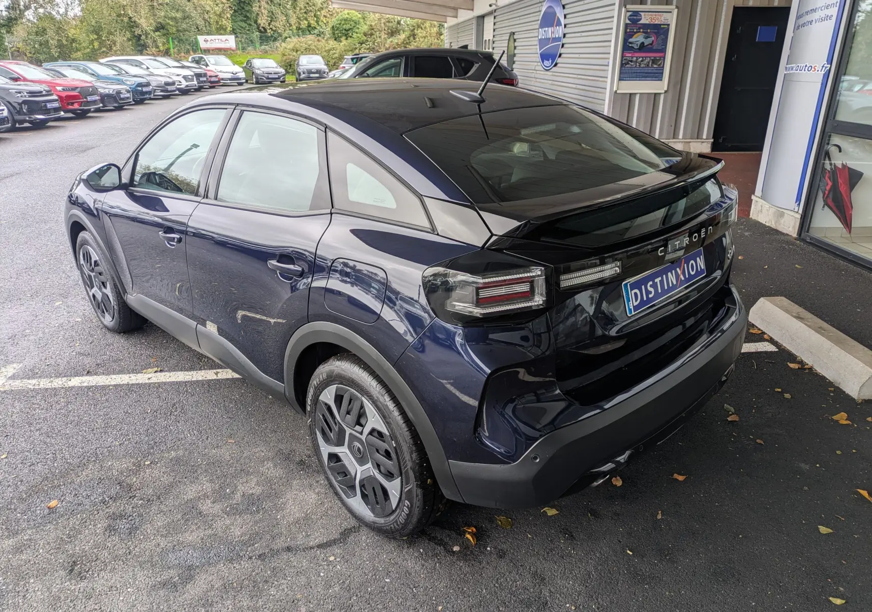 Vue 3/4 arrière droite d'une Citroën C4 Hybrid 145 E-DCS6 Plus bleu foncé avec jantes 18 pouces et feux arrière distinctifs.