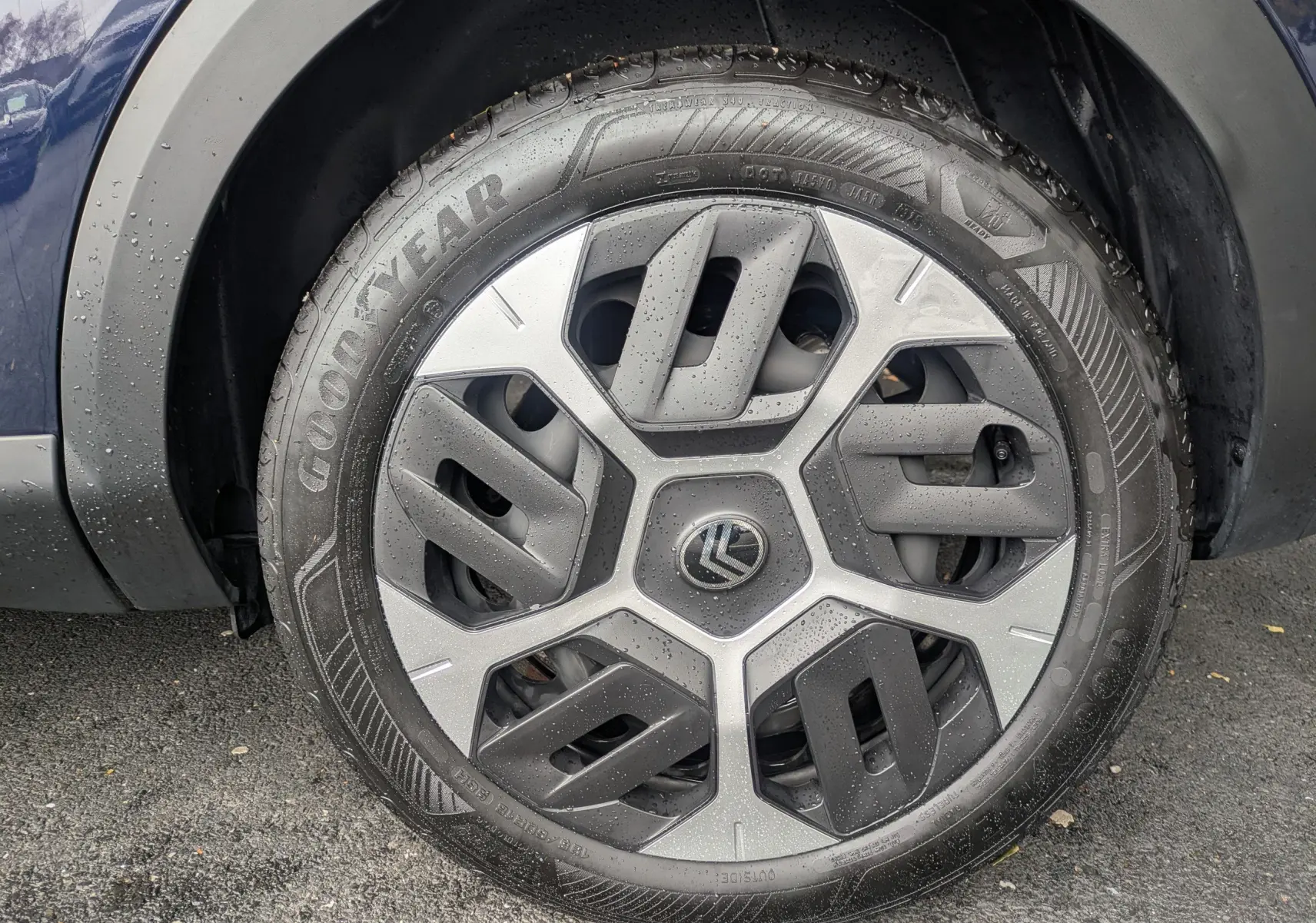 Gros plan sur la roue avant gauche d'une Citroën C4 Hybrid 145 E-DCS6 Plus bleu foncé avec jante tôle 18 pouces et pneus Goodyear.
