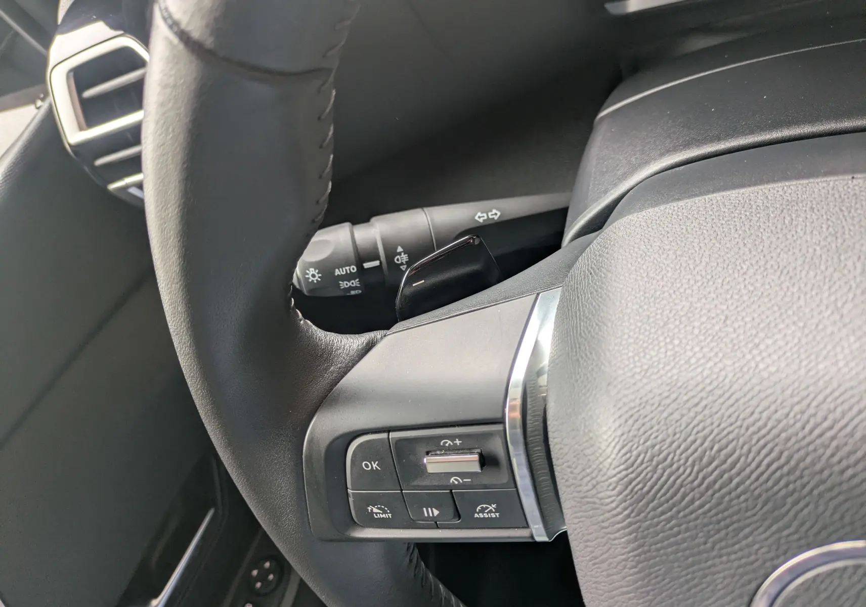 Vue intérieure côté conducteur de la Citroën C4 Hybrid 145 E-DCS6 Plus 2025, sellerie tissu/TEP gris et bleu foncé.