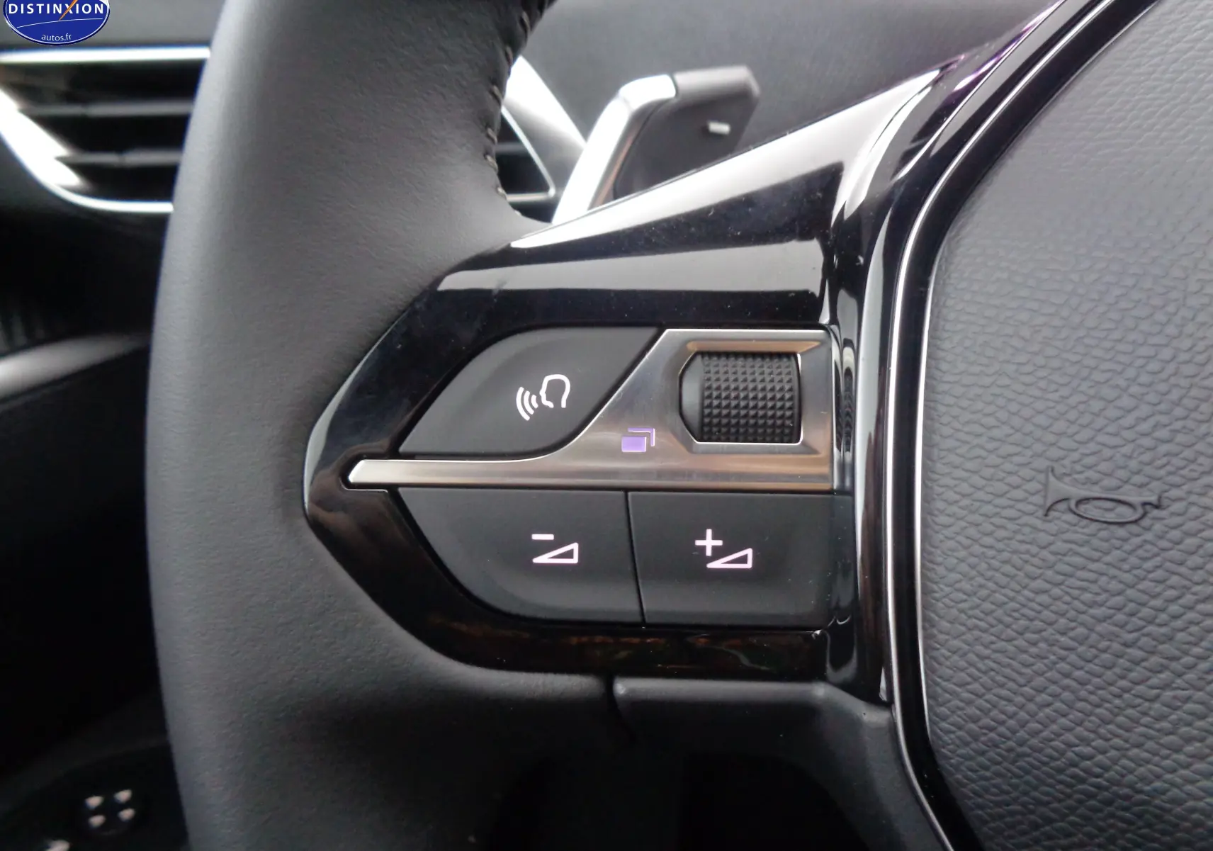 Gros plan sur les commandes du volant à gauche du Peugeot 5008 2023, finition Active Pack, intérieur noir.