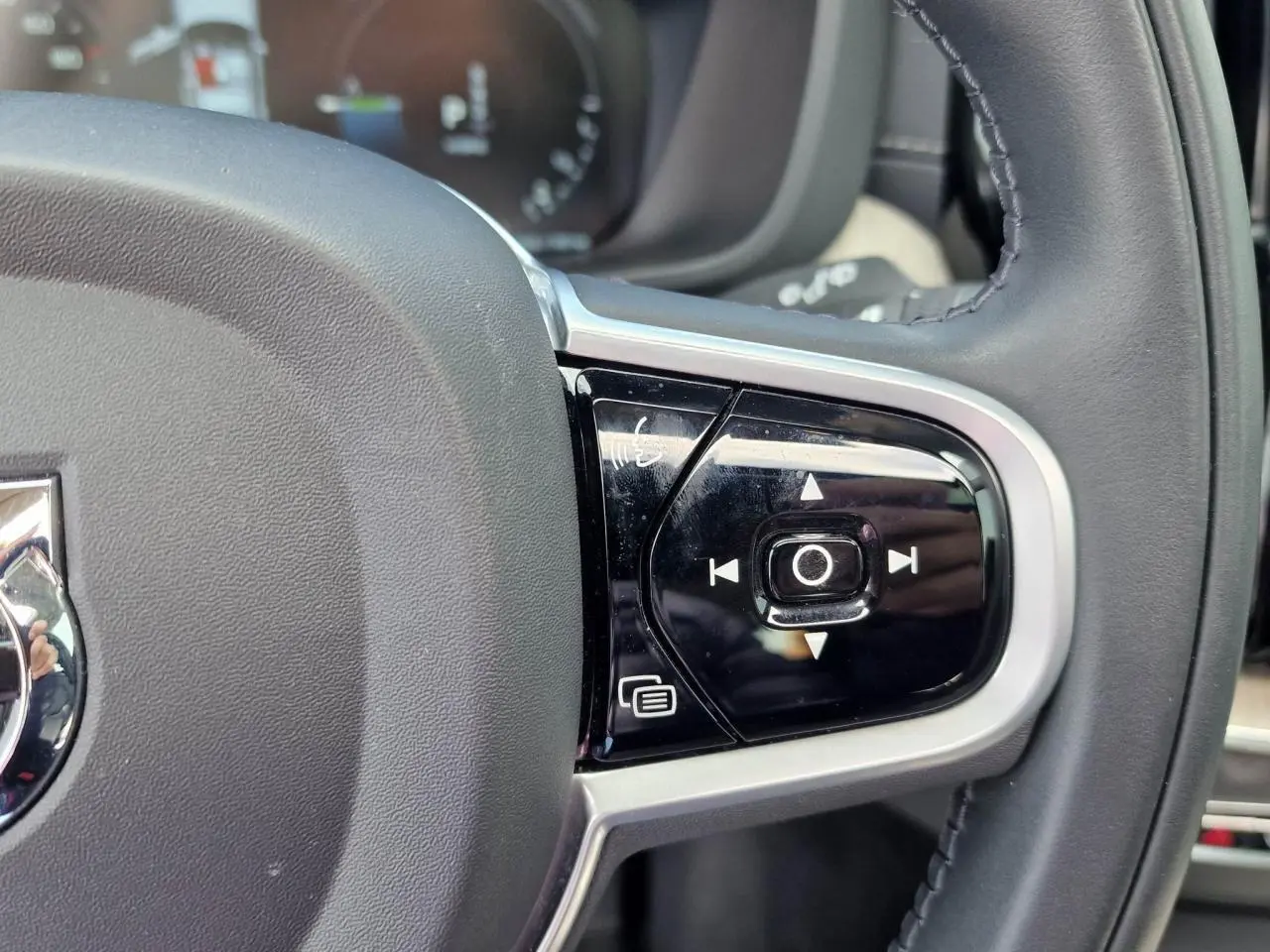 Gros plan sur les commandes multifonctions à droite du volant noir du Volvo XC60 II Recharge T6 340 Inscription Luxe.