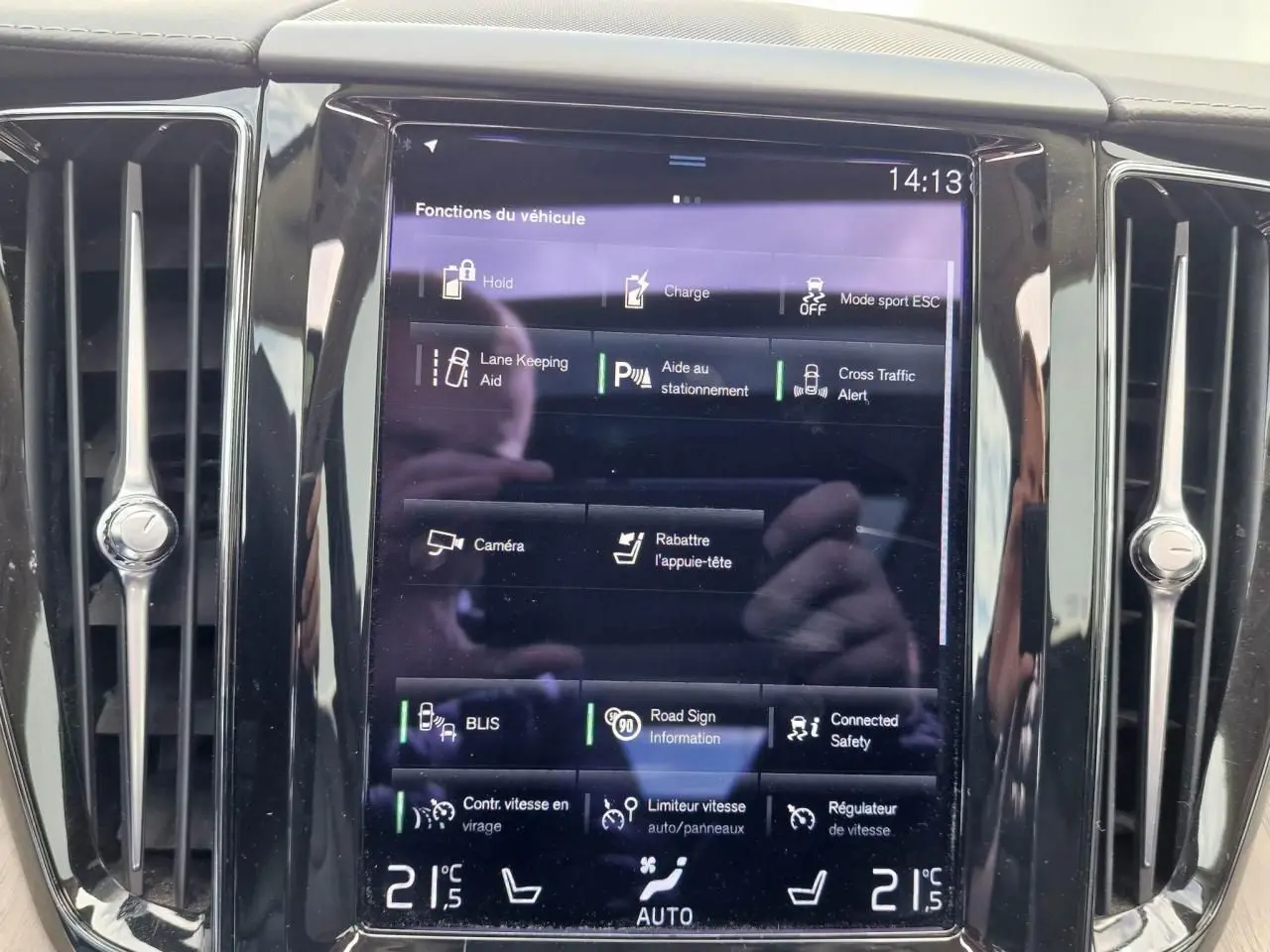 Écran tactile central du tableau de bord du Volvo XC60 noir, affichant les fonctions d’aide à la conduite.