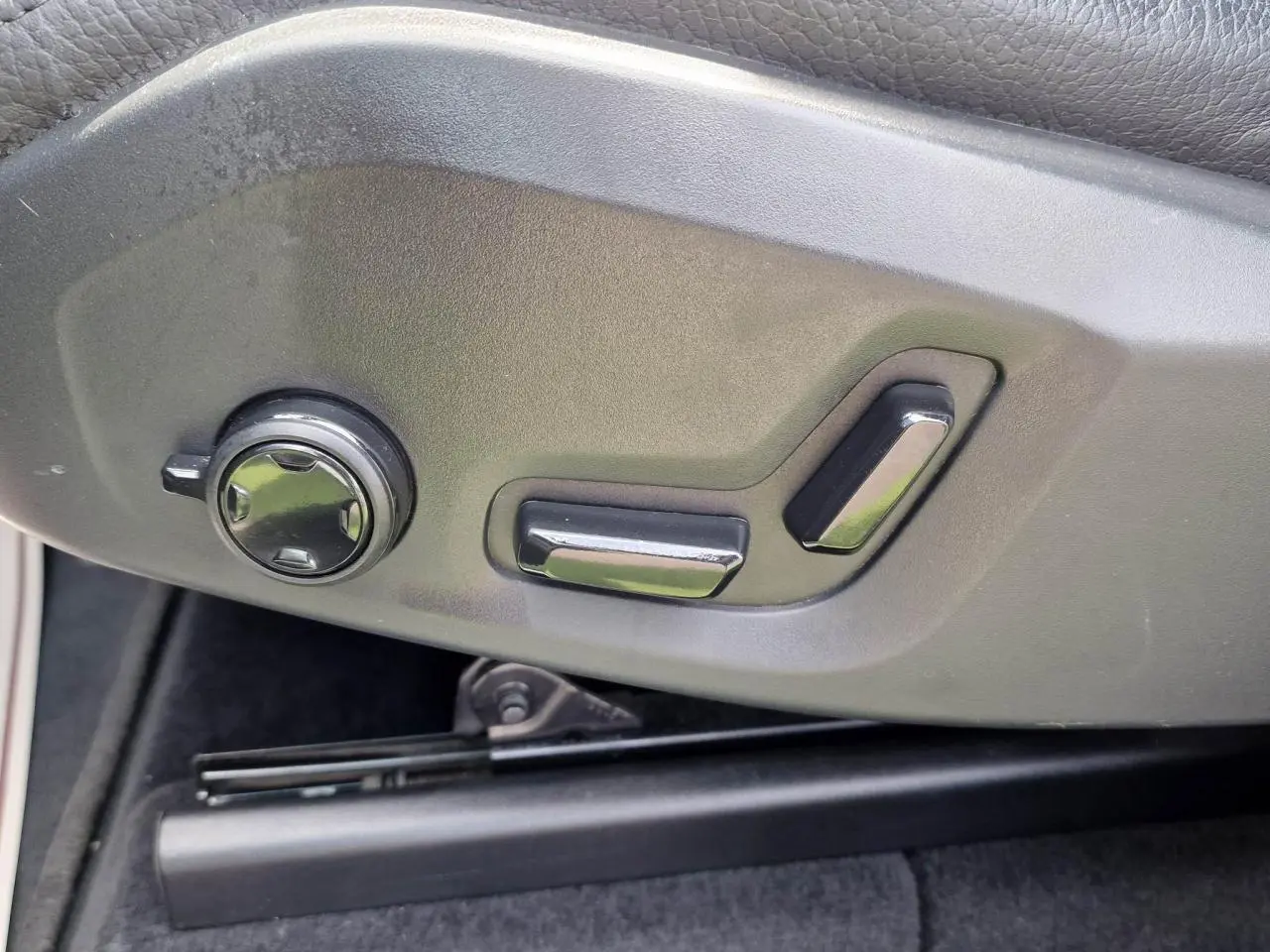Commandes électriques de réglage du siège avant sur Volvo XC60 noir, vue rapprochée côté gauche.