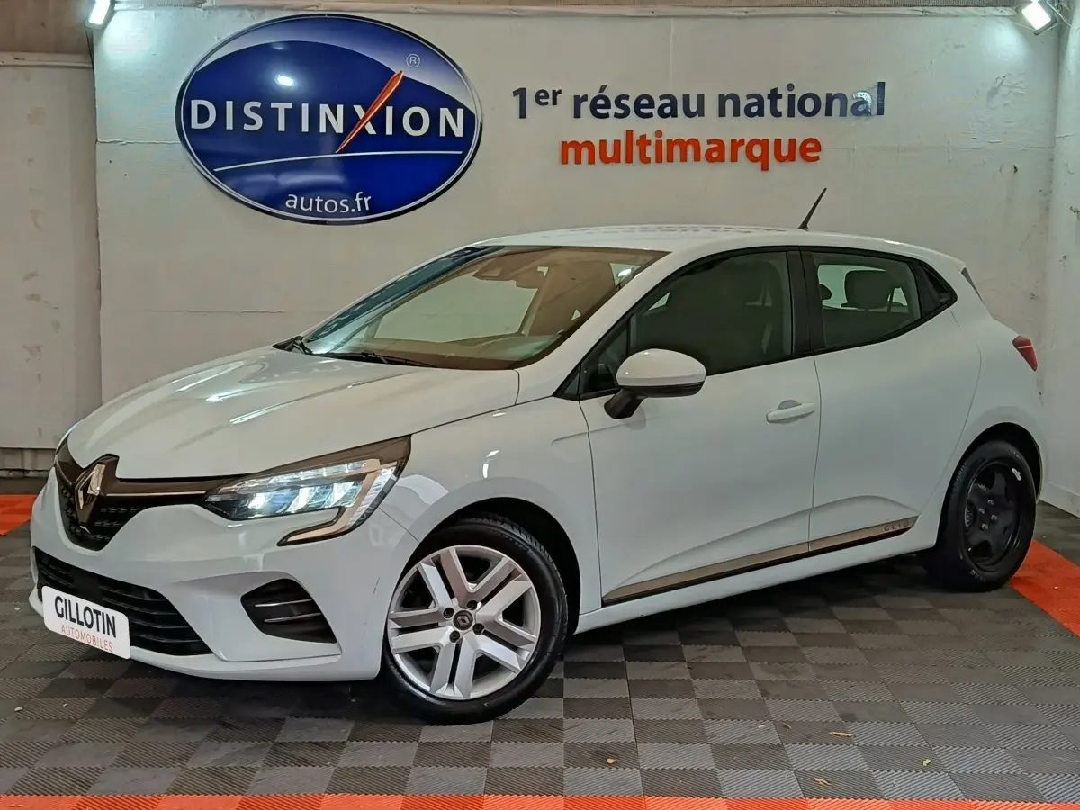 Renault Clio Business TCe 90 blanc vue 3/4 avant droit en intérieur avec jantes différentes à l'avant et à l'arrière.