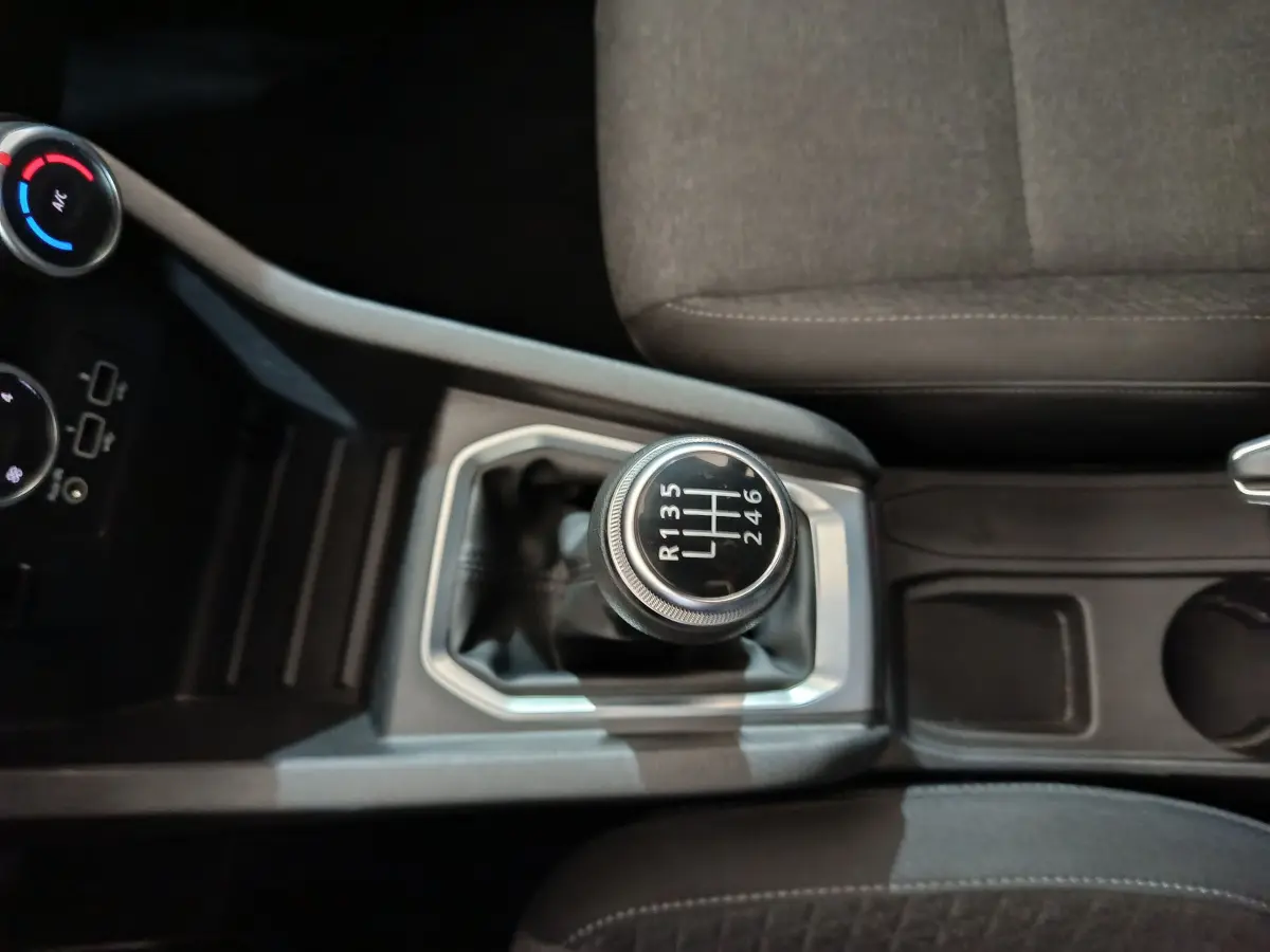 Gros plan sur le levier de vitesses manuel de la Renault Clio Business TCe 90 2021, avec sièges gris visibles.