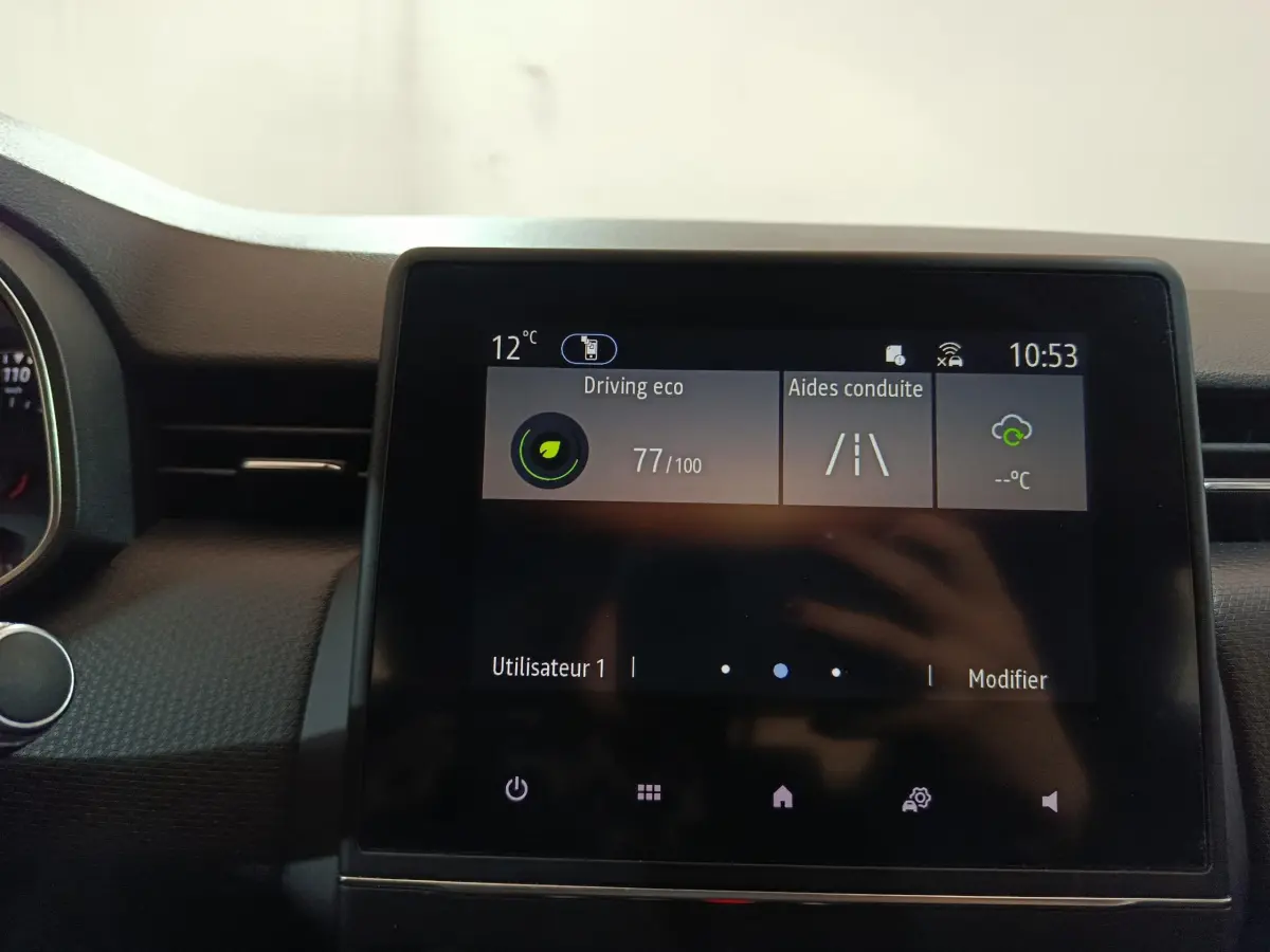 Écran tactile central de la Renault Clio Business blanc 2021 affichant l'aide à la conduite et la température extérieure.