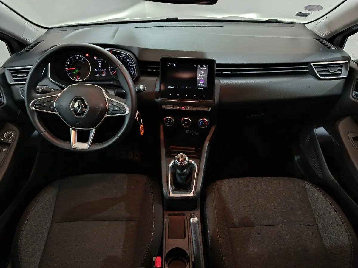 Intérieur de Renault Clio Business TCe 90 2021, vue frontale du tableau de bord et volant cuir noir avec boîte manuelle.