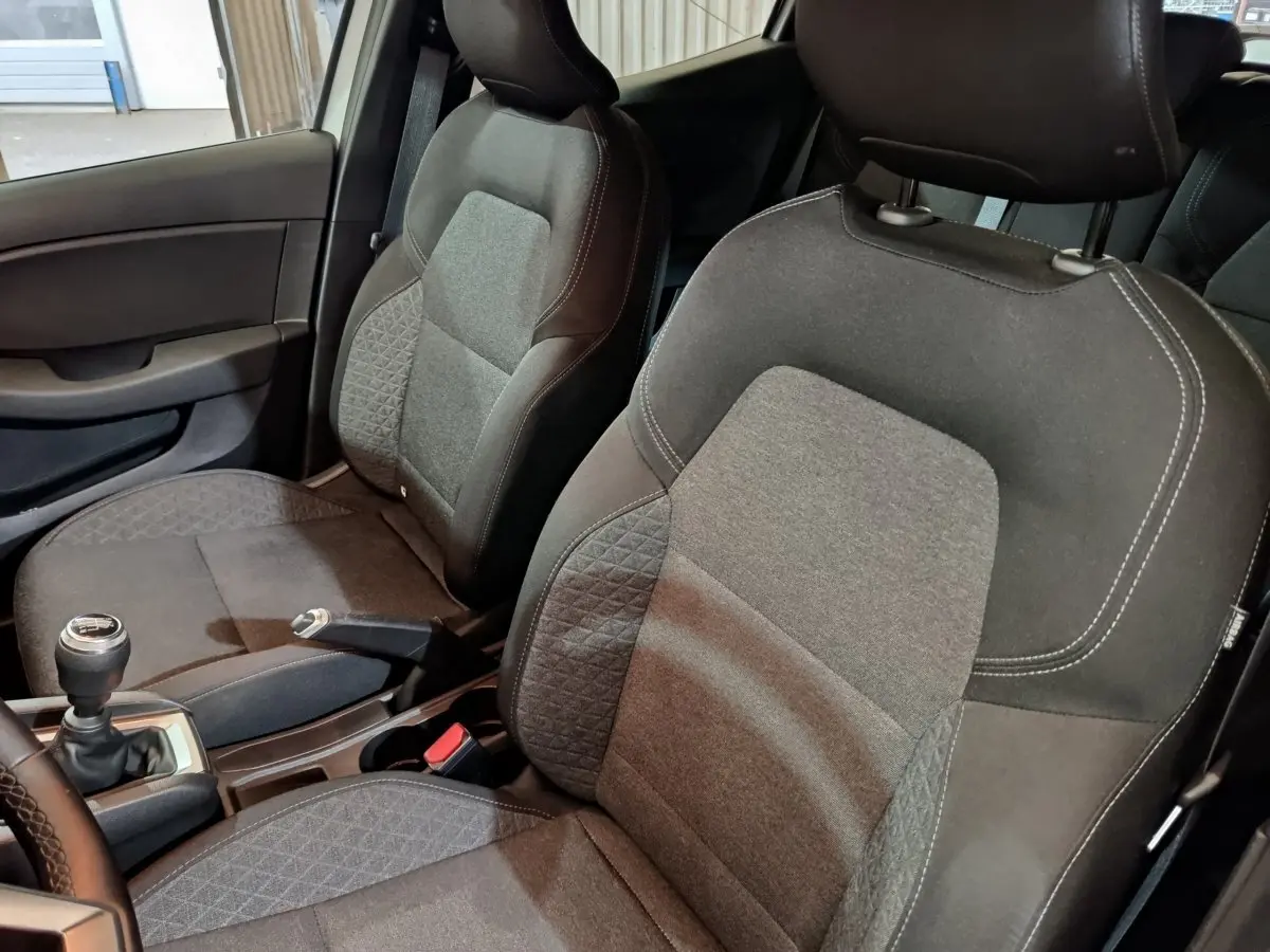 Vue intérieure rapprochée des sièges avant gris foncé et tissu texturé de la Renault Clio Business TCe 90 2021.