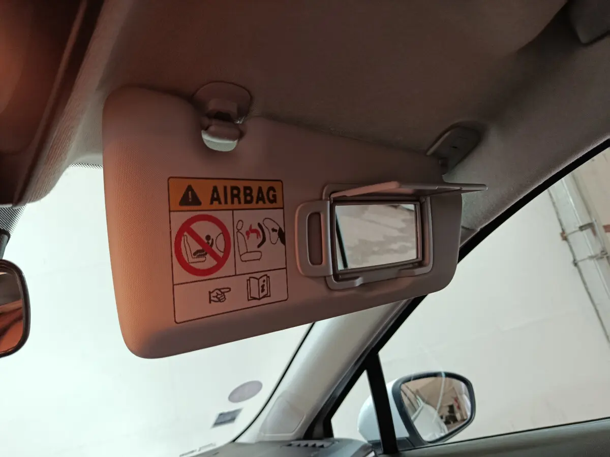 Miroir de courtoisie ouvert sur pare-soleil côté conducteur dans l'habitacle d'une Renault Clio blanche 2021.