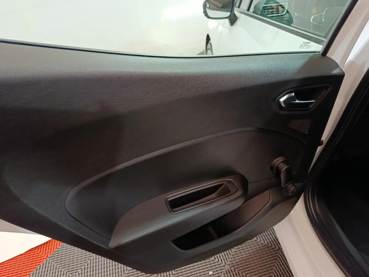 Vue du panneau de porte arrière droite noir mat d'une Renault Clio Business blanche, avec poignée et manivelle de vitre.