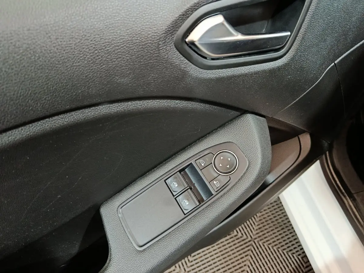 Détail des commandes de lève-vitres et rétroviseurs sur la porte côté conducteur d'une Renault Clio blanche 2021.