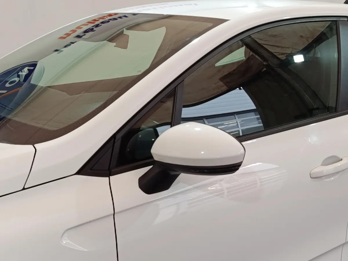 Vue rapprochée du rétroviseur côté gauche blanc d'une Renault Clio Business TCe 90 2021, avec porte et vitre teintée.