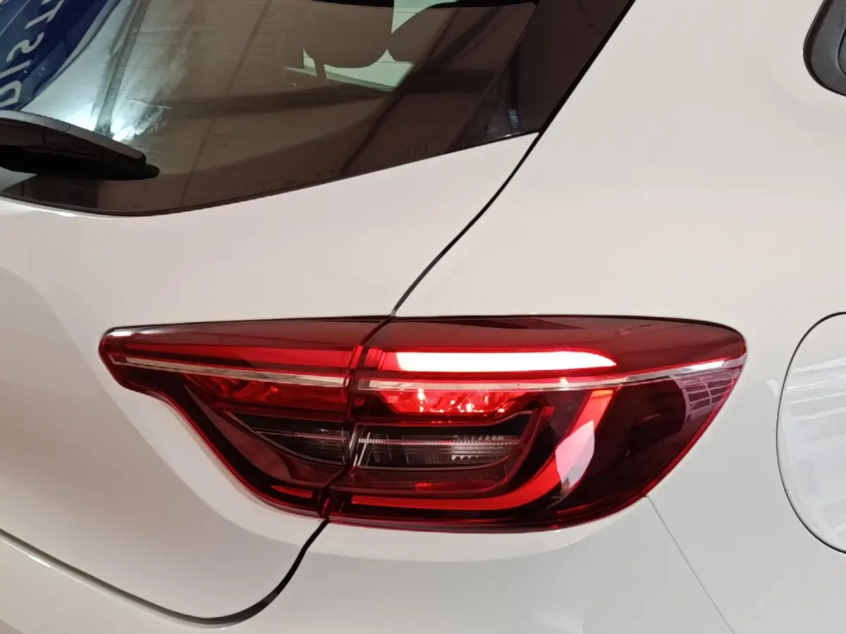 Gros plan sur le feu arrière droit rouge d'une Renault Clio Business blanche, mettant en valeur ses lignes modernes.