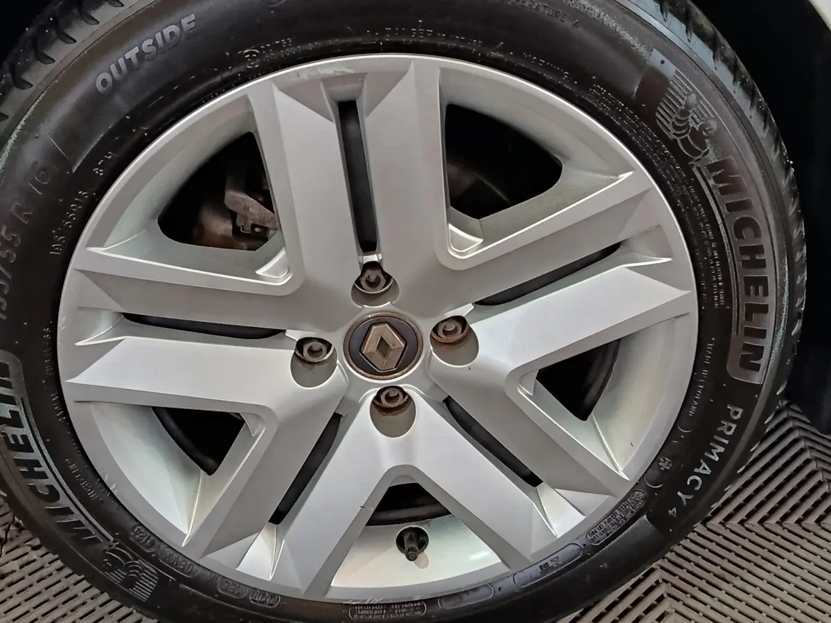 Gros plan sur la jante alliage argentée avec logo Renault au centre d'une Renault Clio blanche de 2021.