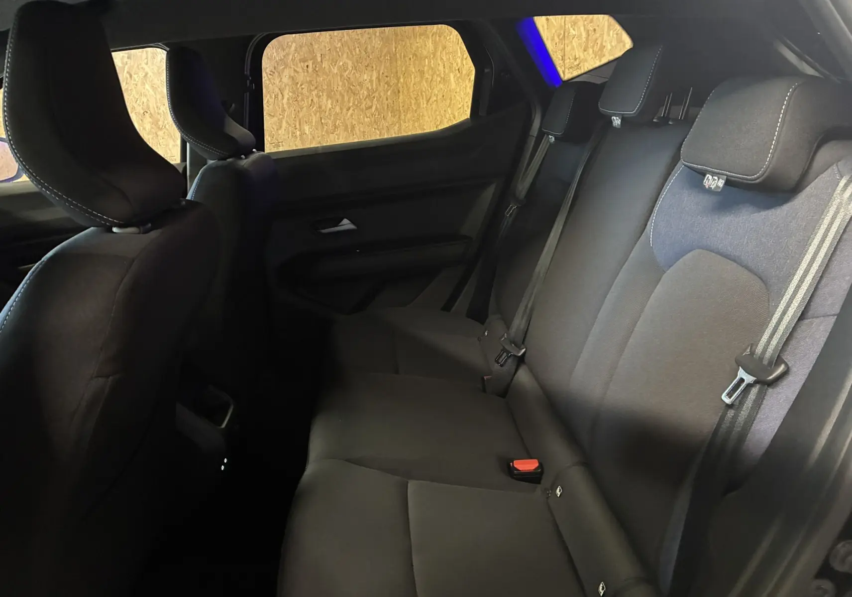 Vue intérieure du côté droit montrant la banquette arrière en tissu gris-noir du Dacia Duster 1.6 Hybrid 140 Journey 2025.