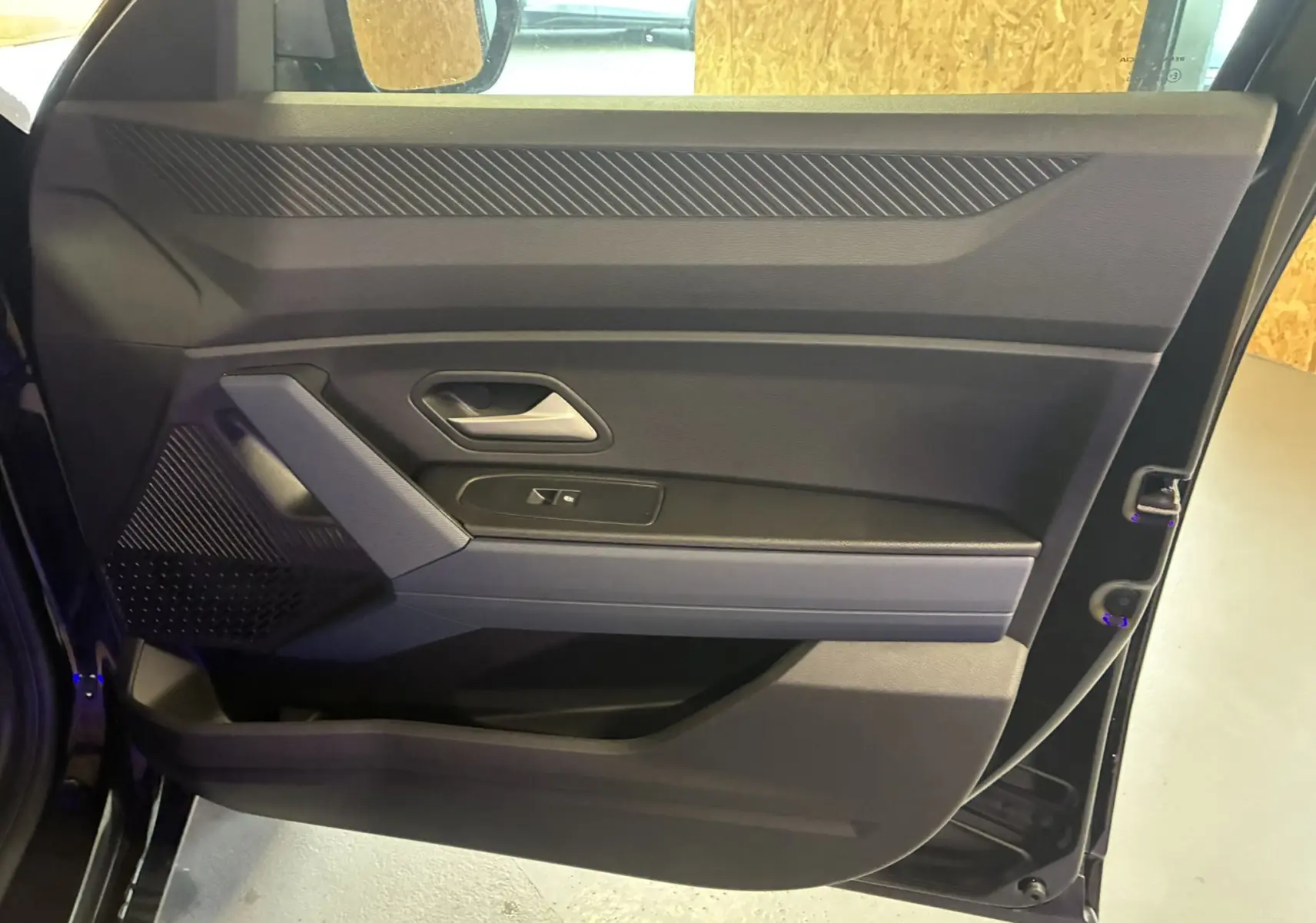 Vue intérieure de la porte côté gauche du Dacia Duster 2025 noir, avec poignée et commande de fenêtre intégrées.