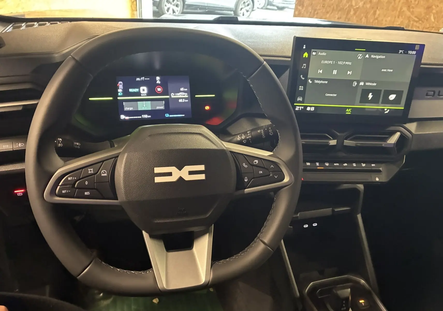 Vue intérieure centrée sur le volant noir et le tableau de bord numérique du Dacia Duster 1.6 Hybrid 140 Journey 2025.