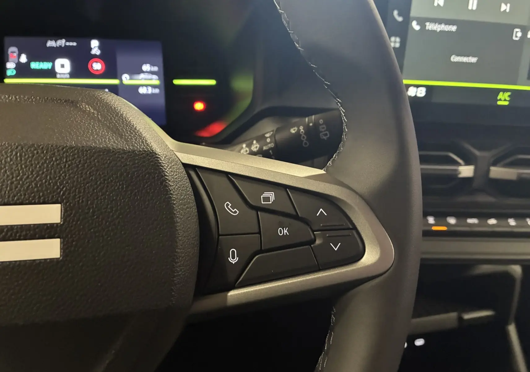 Gros plan sur les commandes au volant côté droit du Dacia Duster 1.6 Hybrid 140 Journey 2025, intérieur noir.