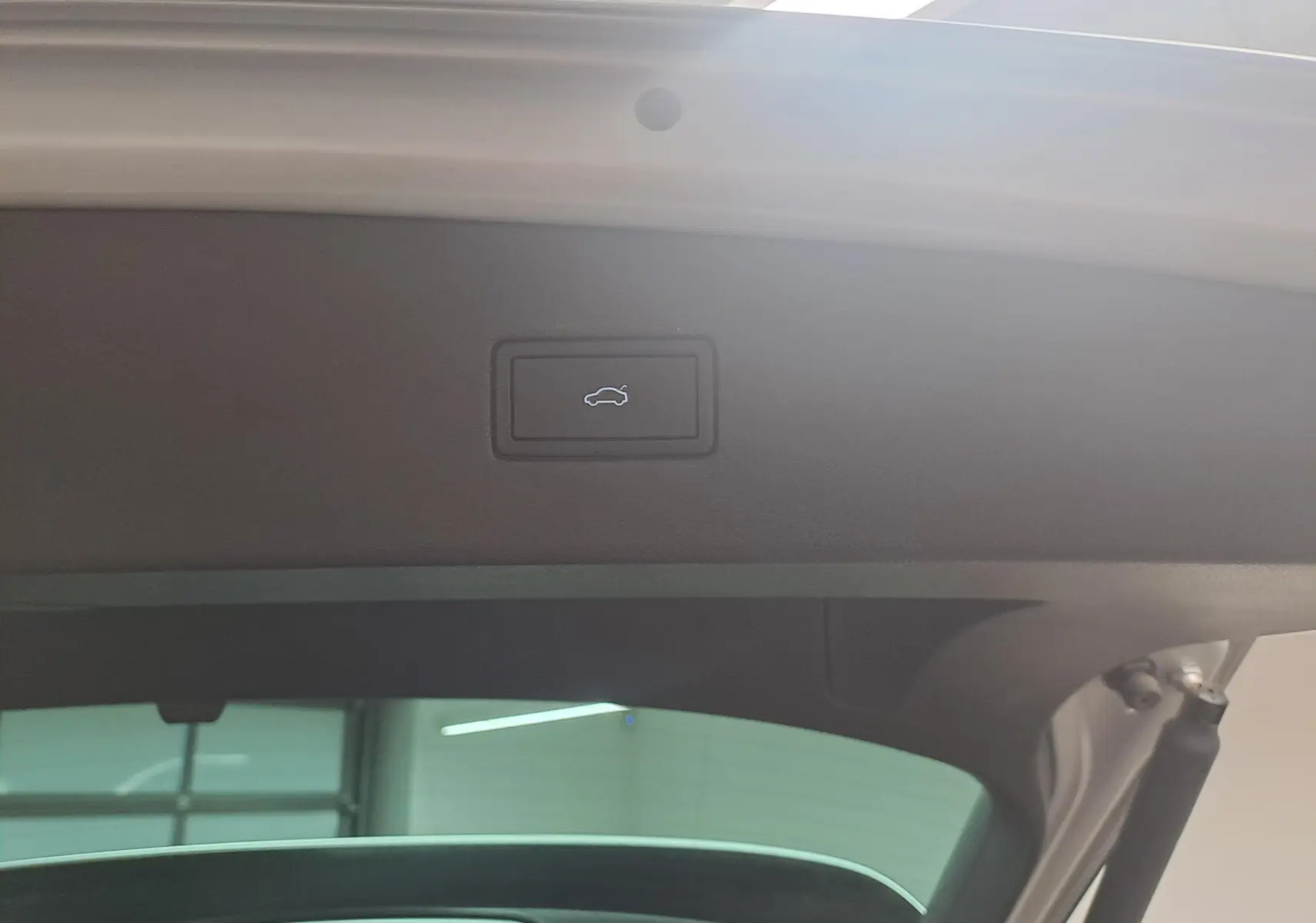 Bouton d'ouverture électrique du coffre sur le hayon intérieur d'un Volkswagen Tiguan 2024 couleur Reflet d'Argent.