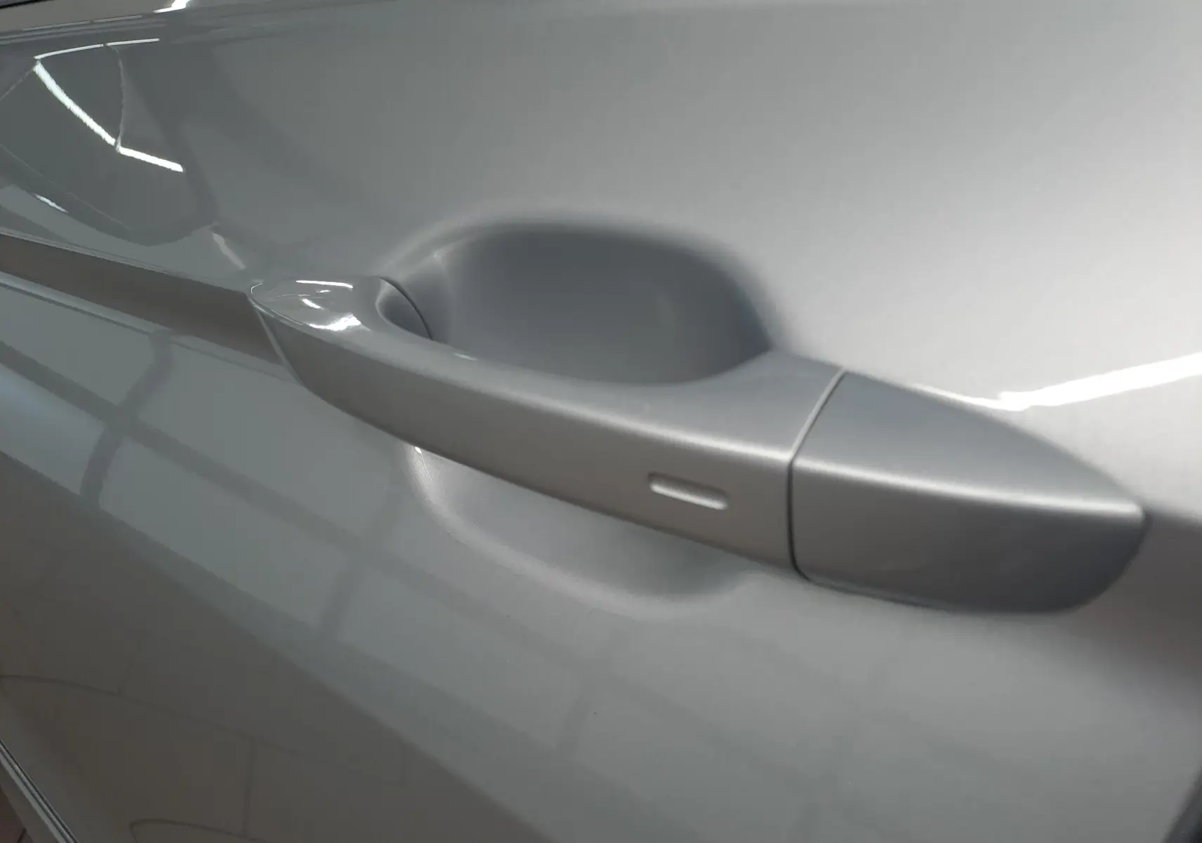 Poignée de porte côté gauche du Volkswagen Tiguan 2024 en Reflet d'Argent, finition R-Line Exclusive.