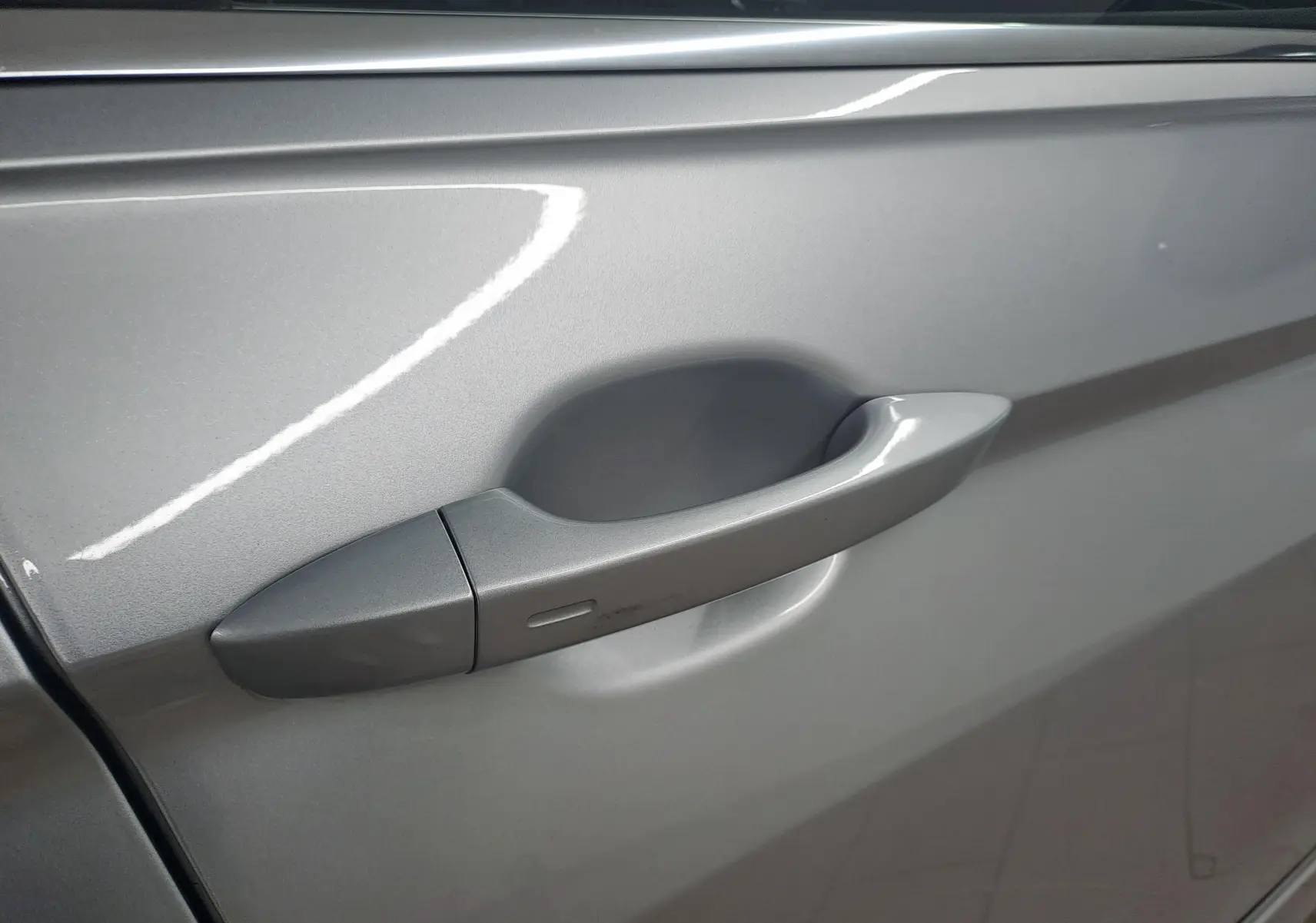 Poignée de porte côté gauche du Volkswagen Tiguan 2024 en peinture métallisée Reflet d'Argent, vue rapprochée.