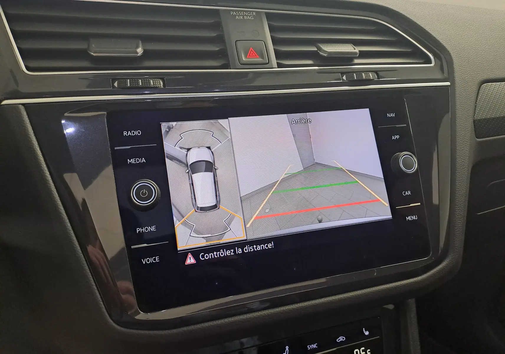 Écran central du Volkswagen Tiguan 2024 montrant la caméra de recul et la vue 360 en intérieur noir brillant.