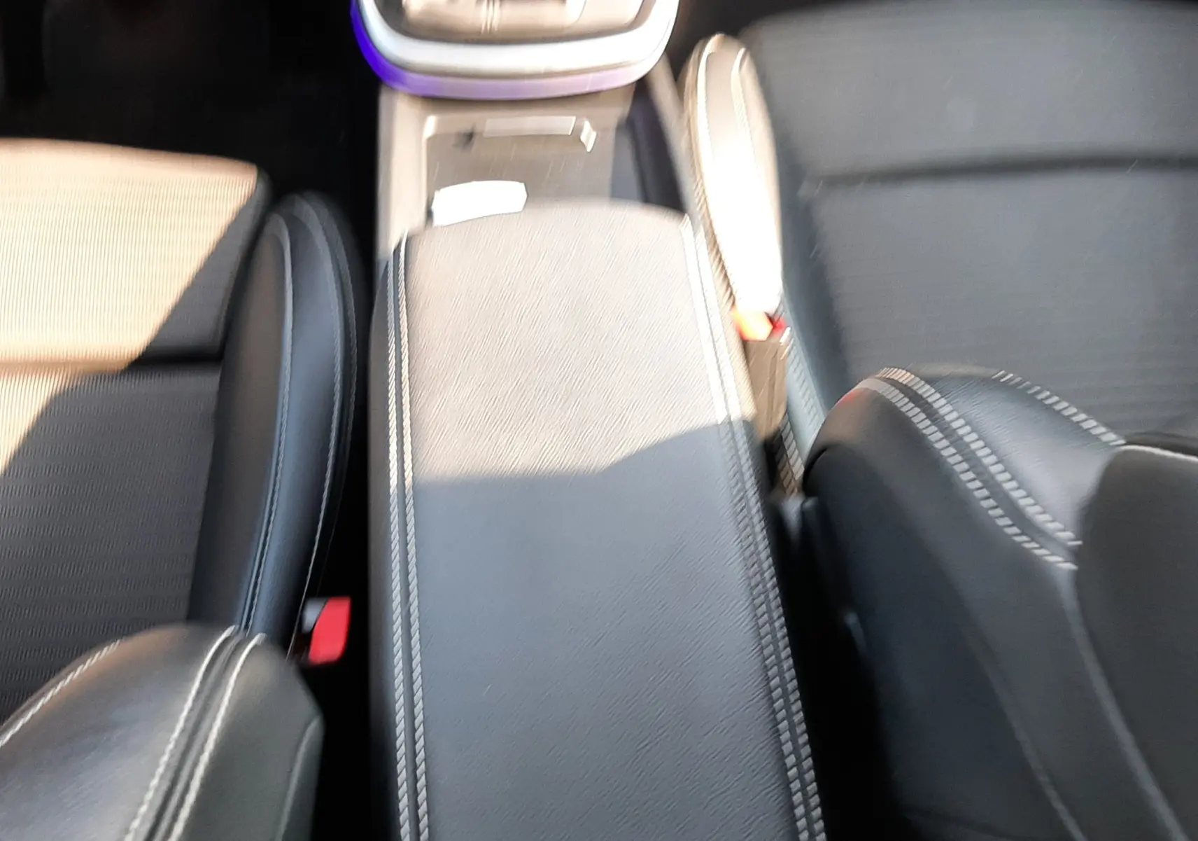 Vue plongeante sur la console centrale et les sièges noirs avec surpiqûres blanches du Renault Scénic IV 1.6 DCI 130 Intens Bose.