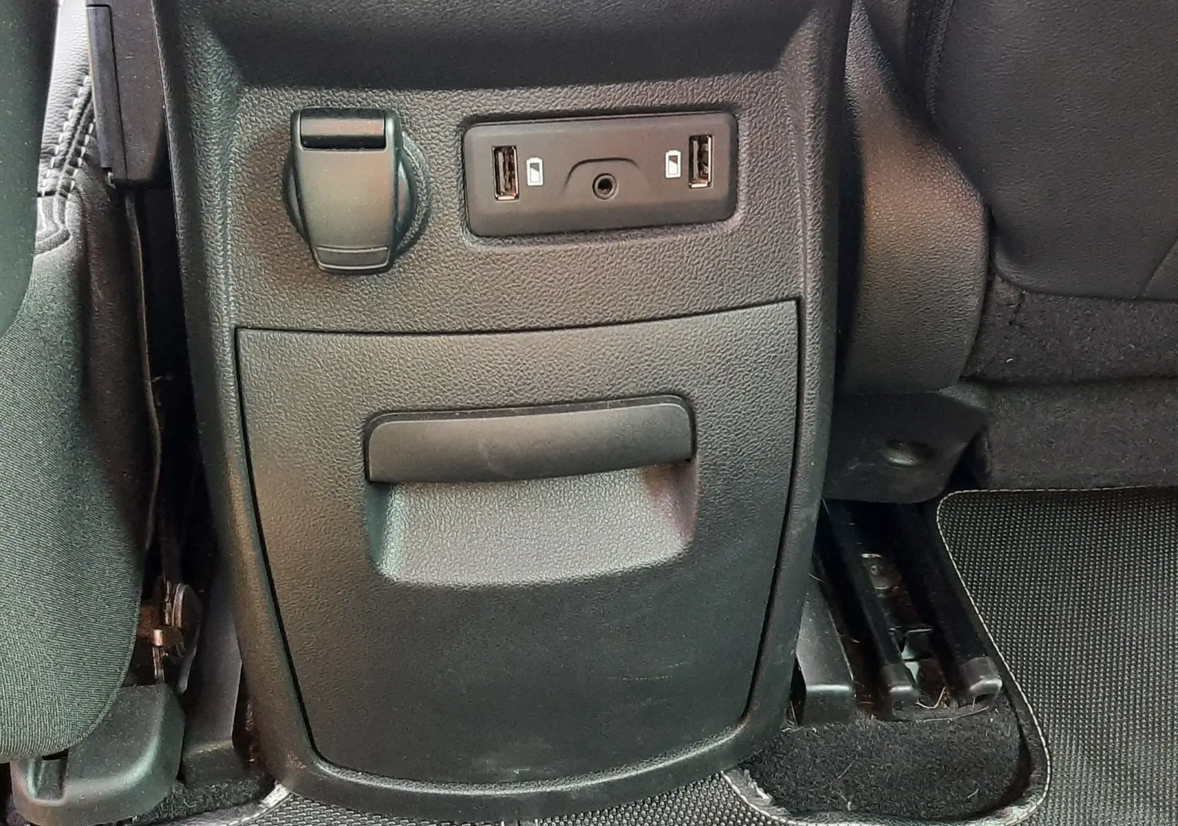 Vue rapprochée de la console arrière noire du Renault Scenic IV avec prises USB et prise 12V.