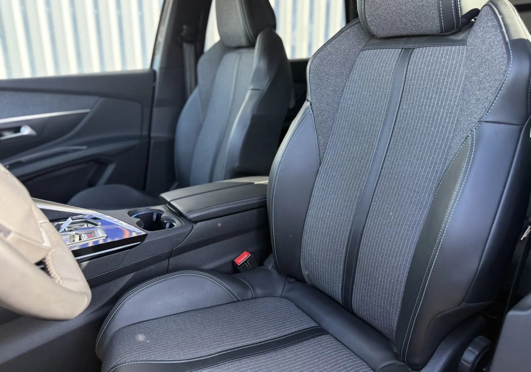 Gros plan sur les sièges avant en tissu gris et cuir noir du Peugeot 5008 1.5 HDi 130 Allure 2021, intérieur moderne.