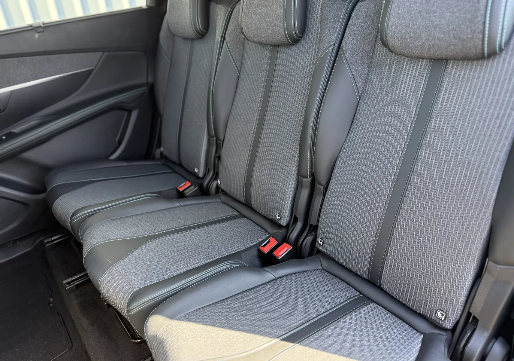 Vue latérale des sièges arrière gris du Peugeot 5008 1.5 HDI 130 Allure 2021, avec finitions tissu et cuir.